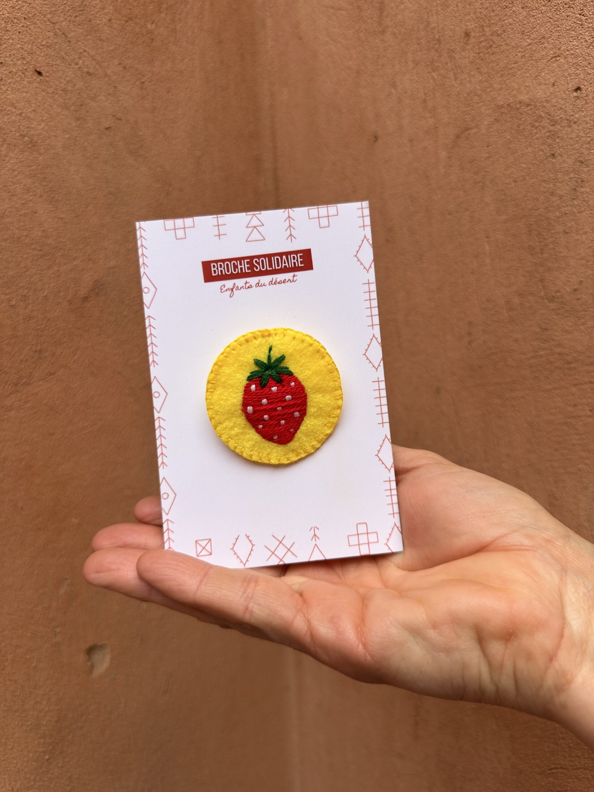 Broche en feutrine décorée d'une fraise brodée.