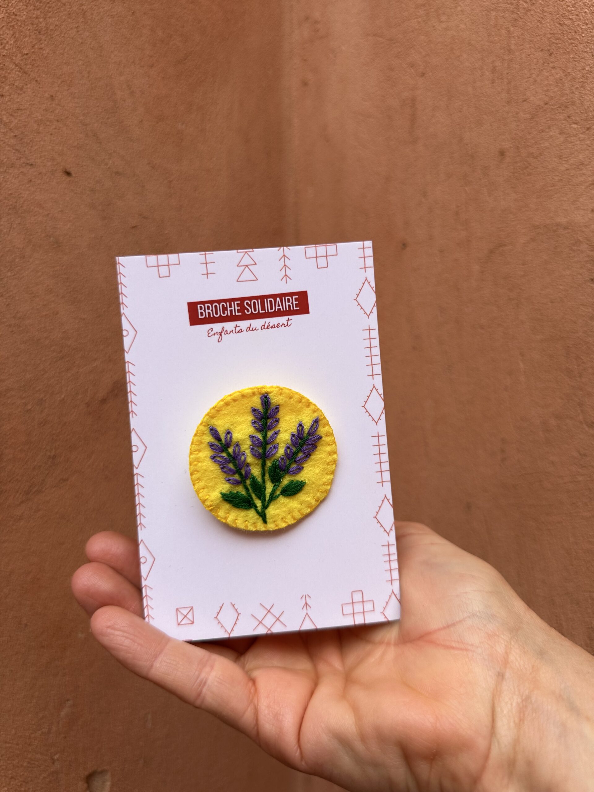 Broche en feutrine fleurie, jaune et violette.