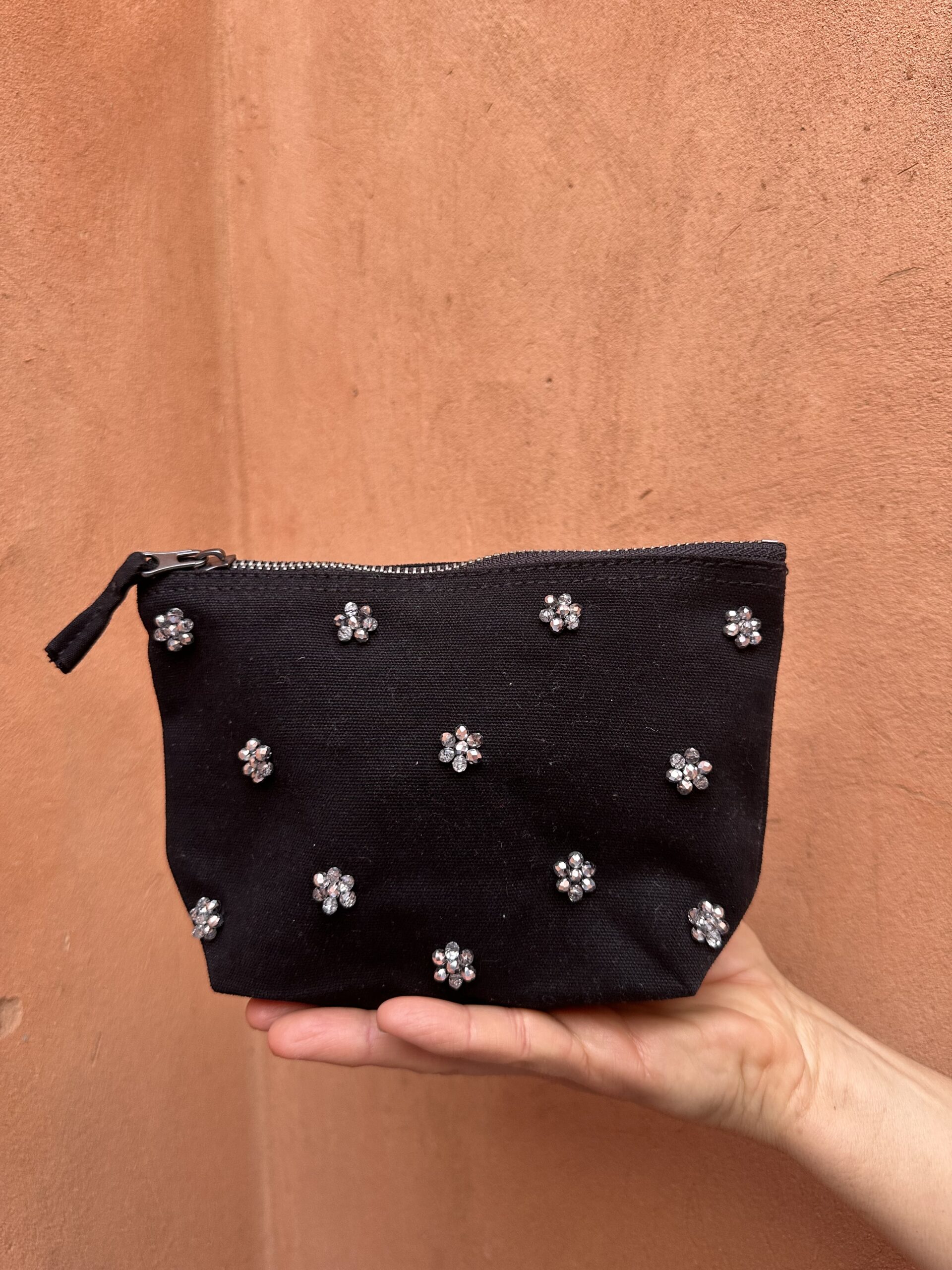 Pochette noire ornée de fleurs scintillantes