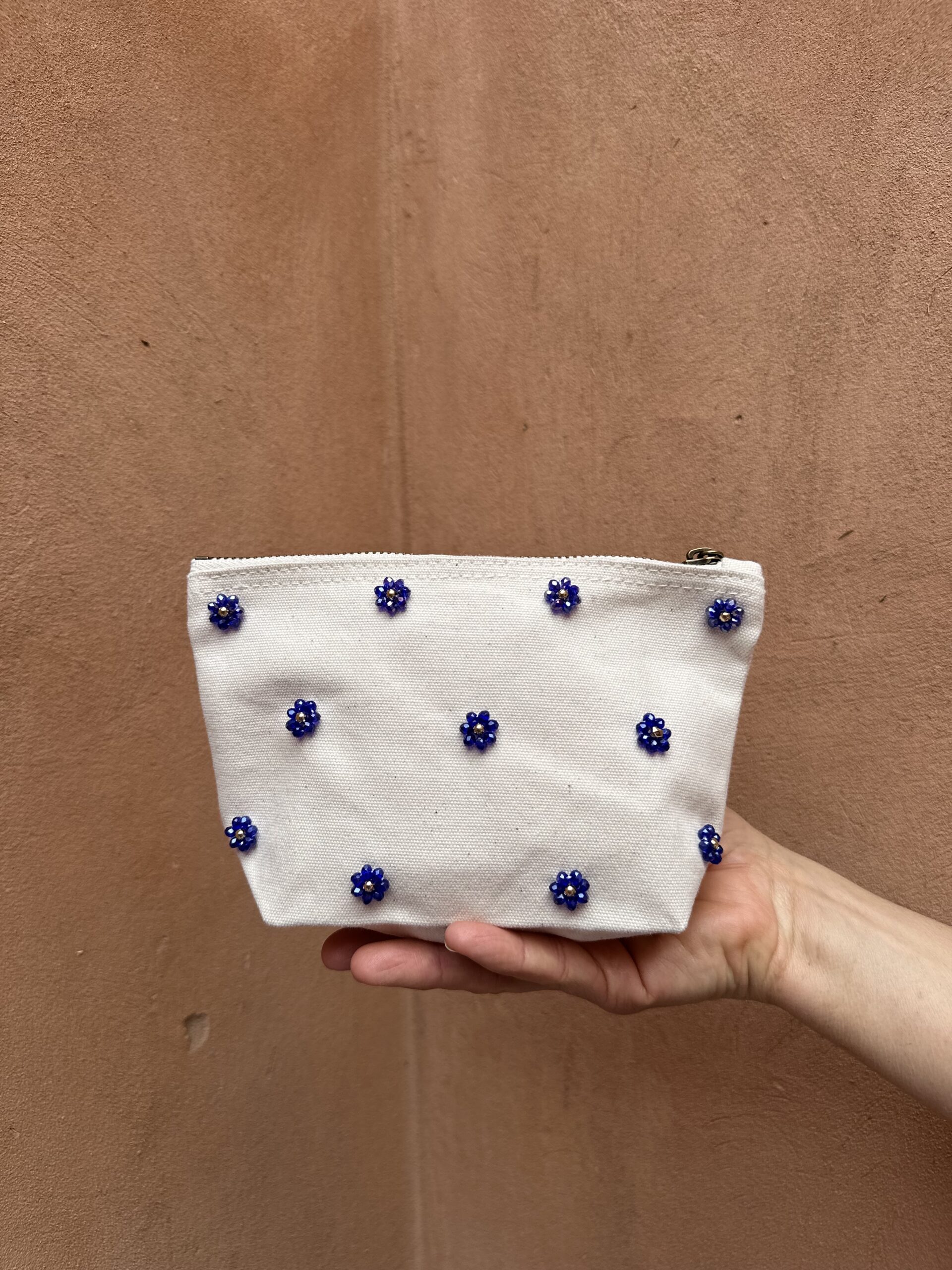 Pochette beige décorée de fleurs bleues