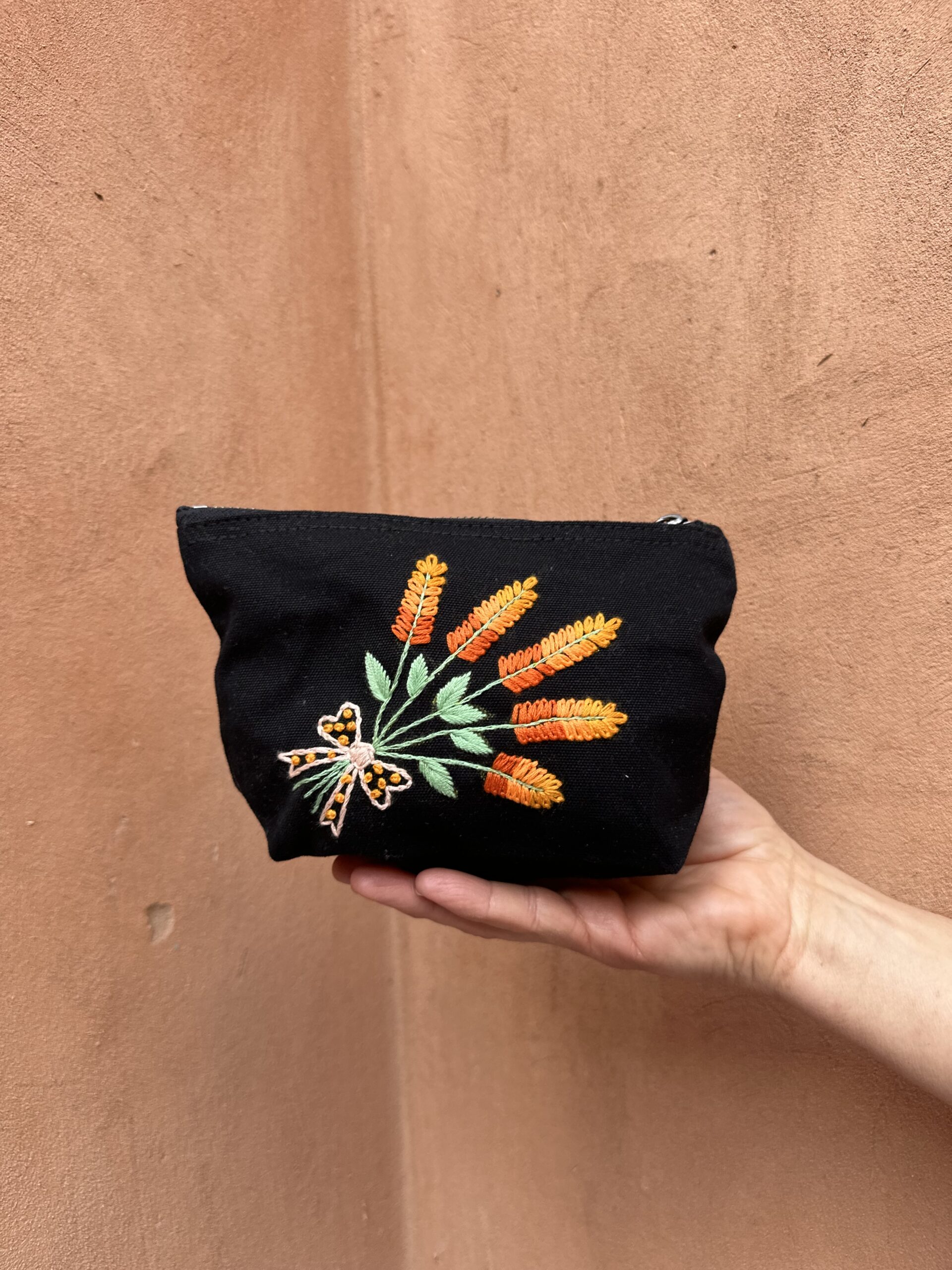 Pochette noire ornée d'un bouquet de fleurs