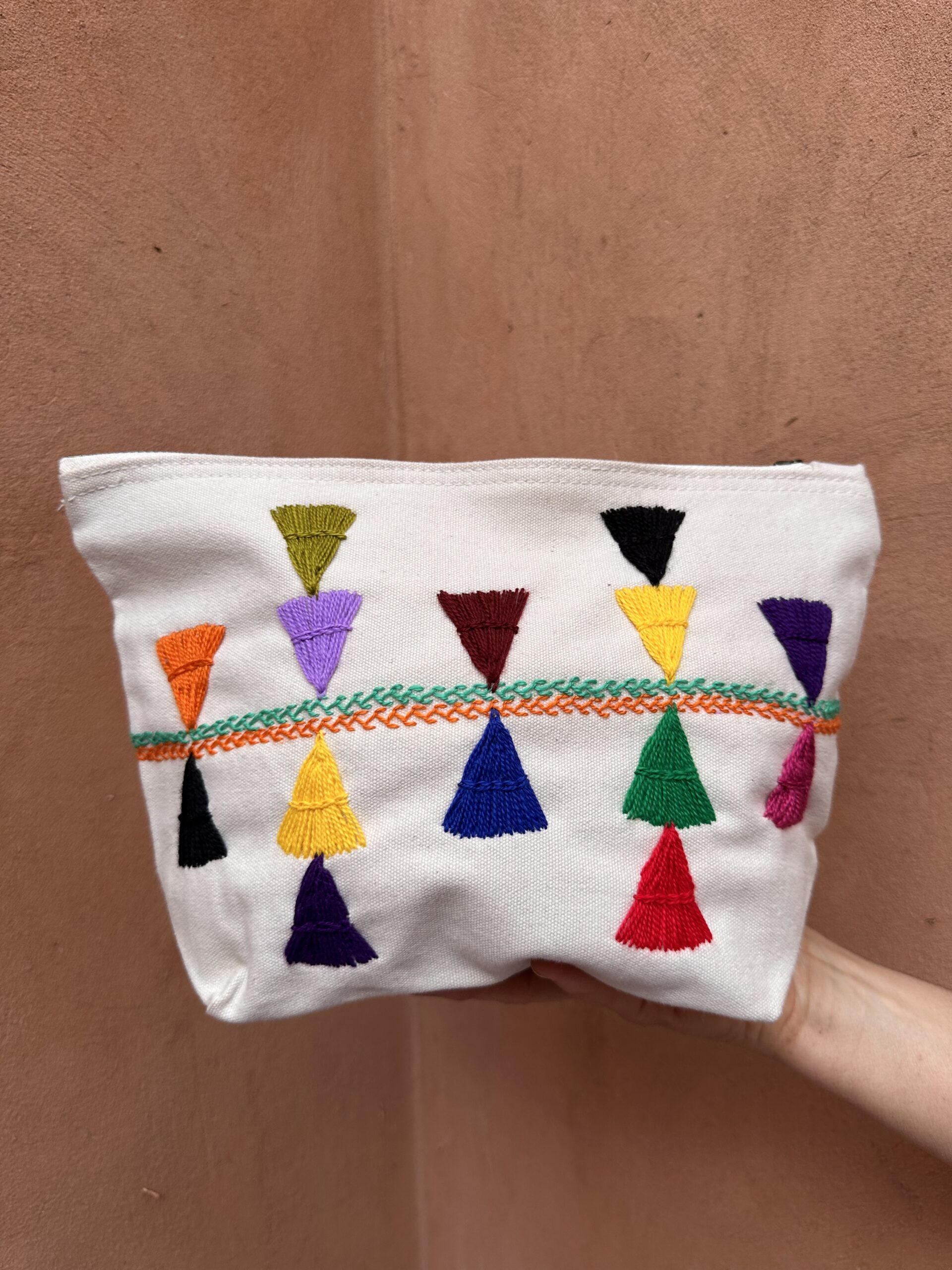 Pochette beige avec motifs d'inspiration berbères colorés.