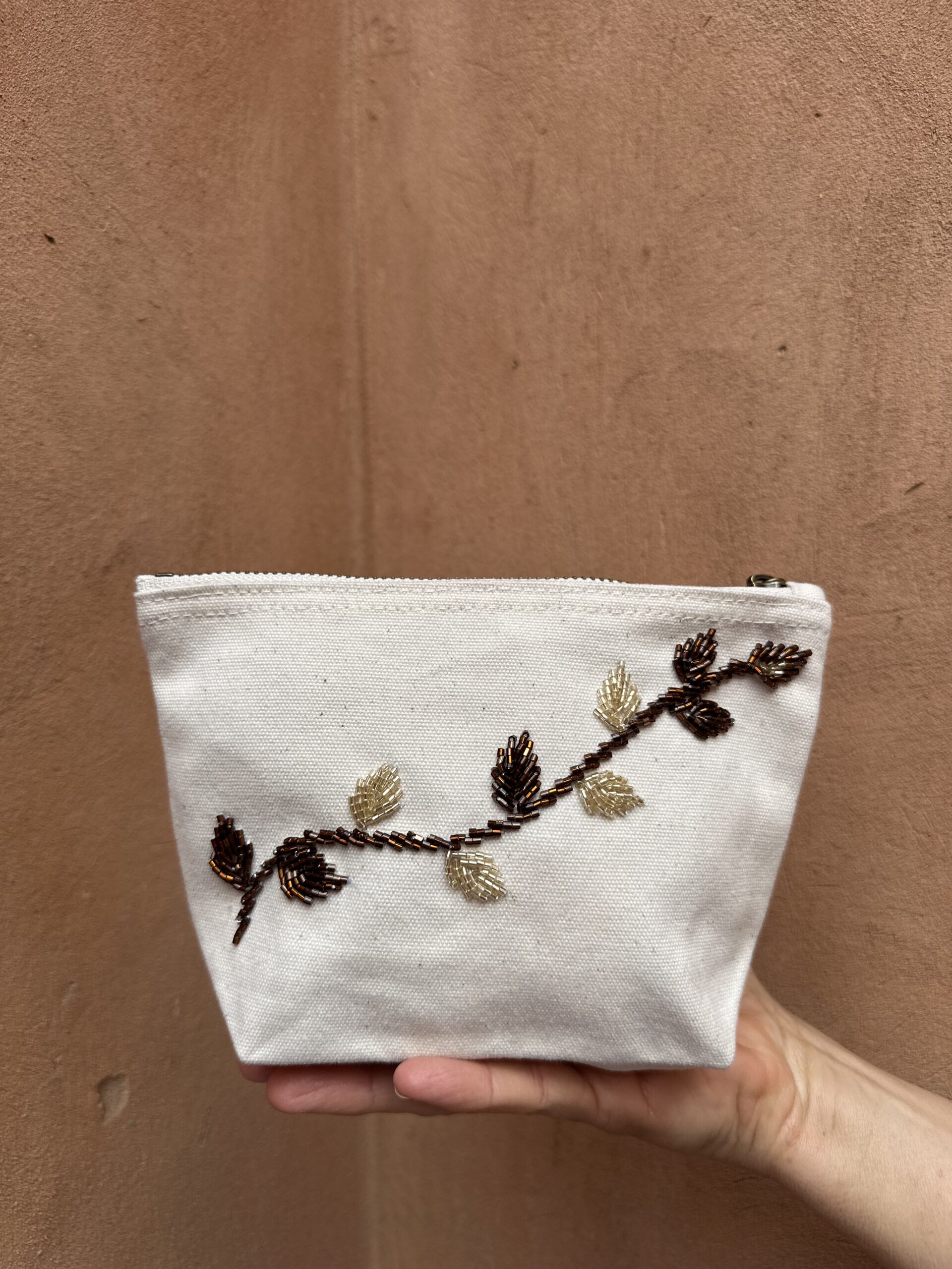 Pochette beige avec broderie de perle.