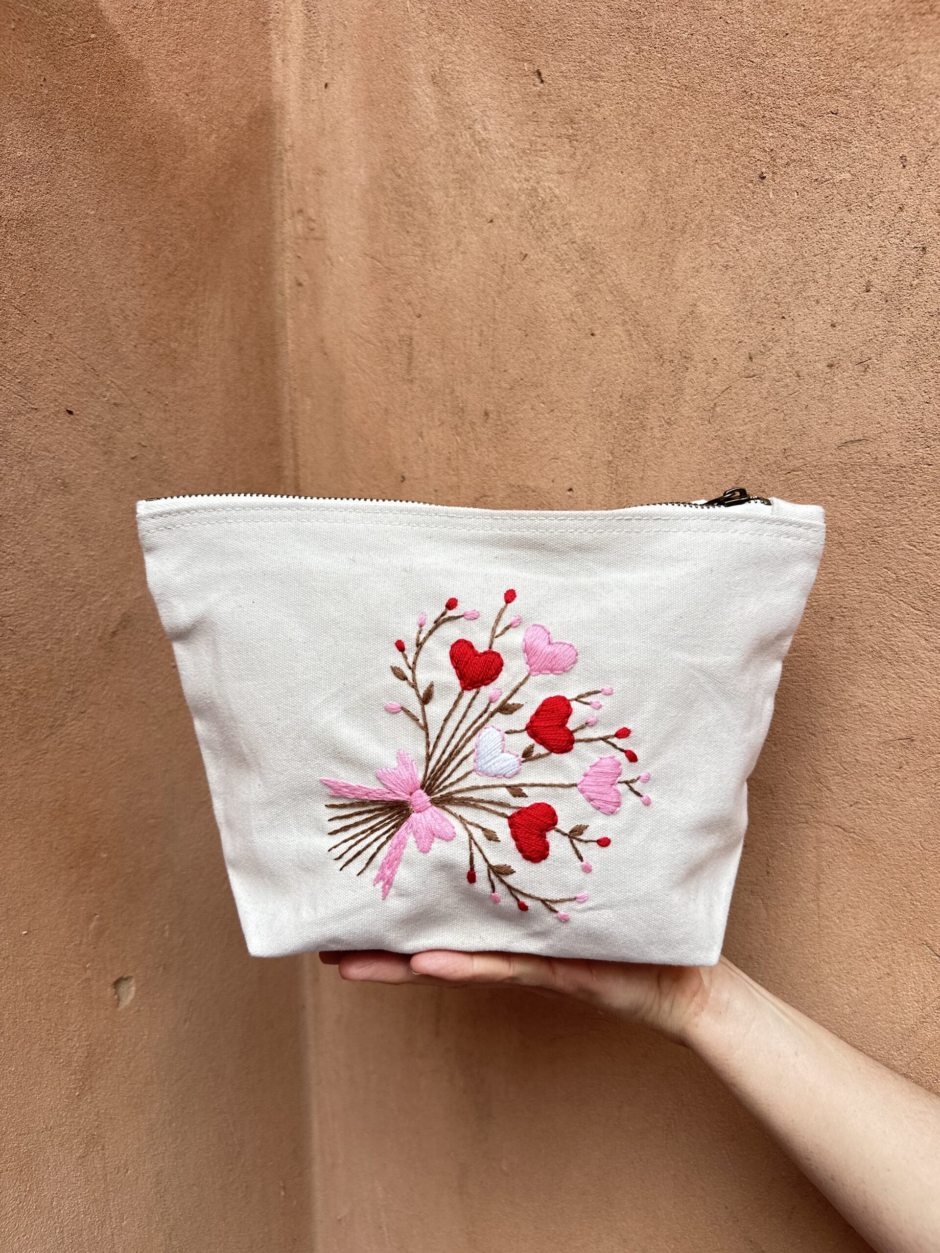 Pochette beige avec broderie fleurie.