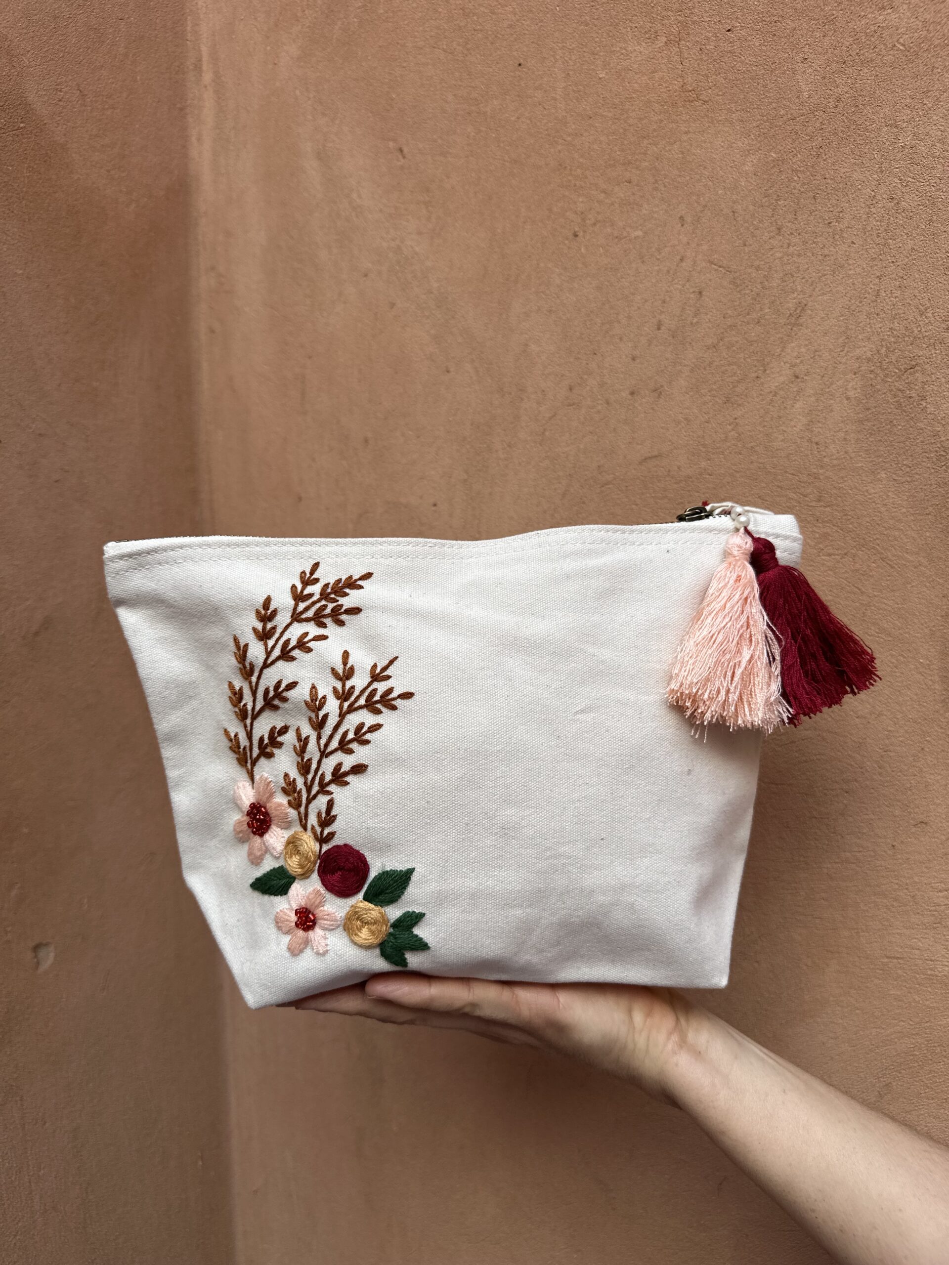 Pochette avec broderie à fleur dans les tons de rose.