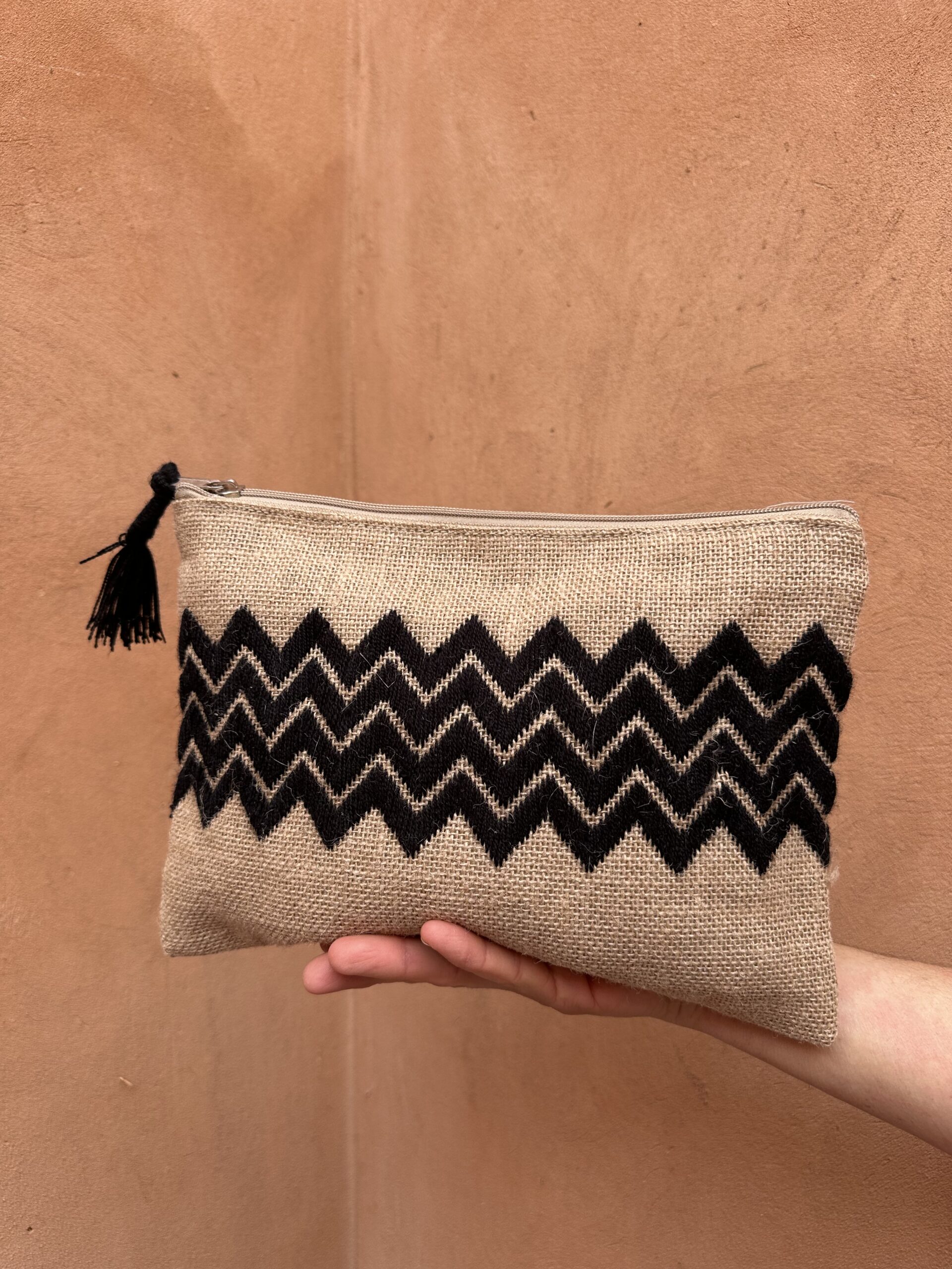 Pochette en jute avec broderie noire.