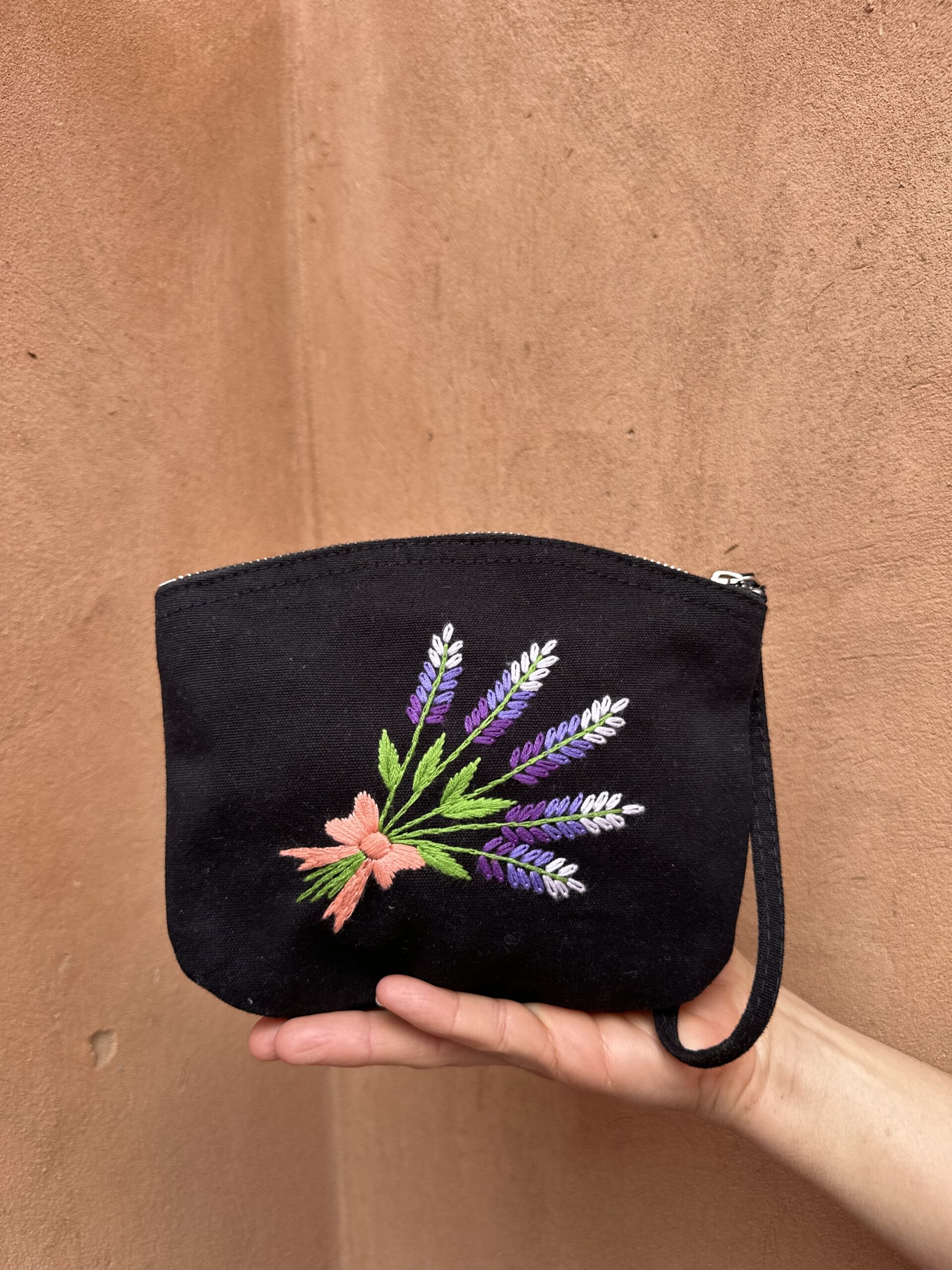 Pochette noire avec broderie de lavande.