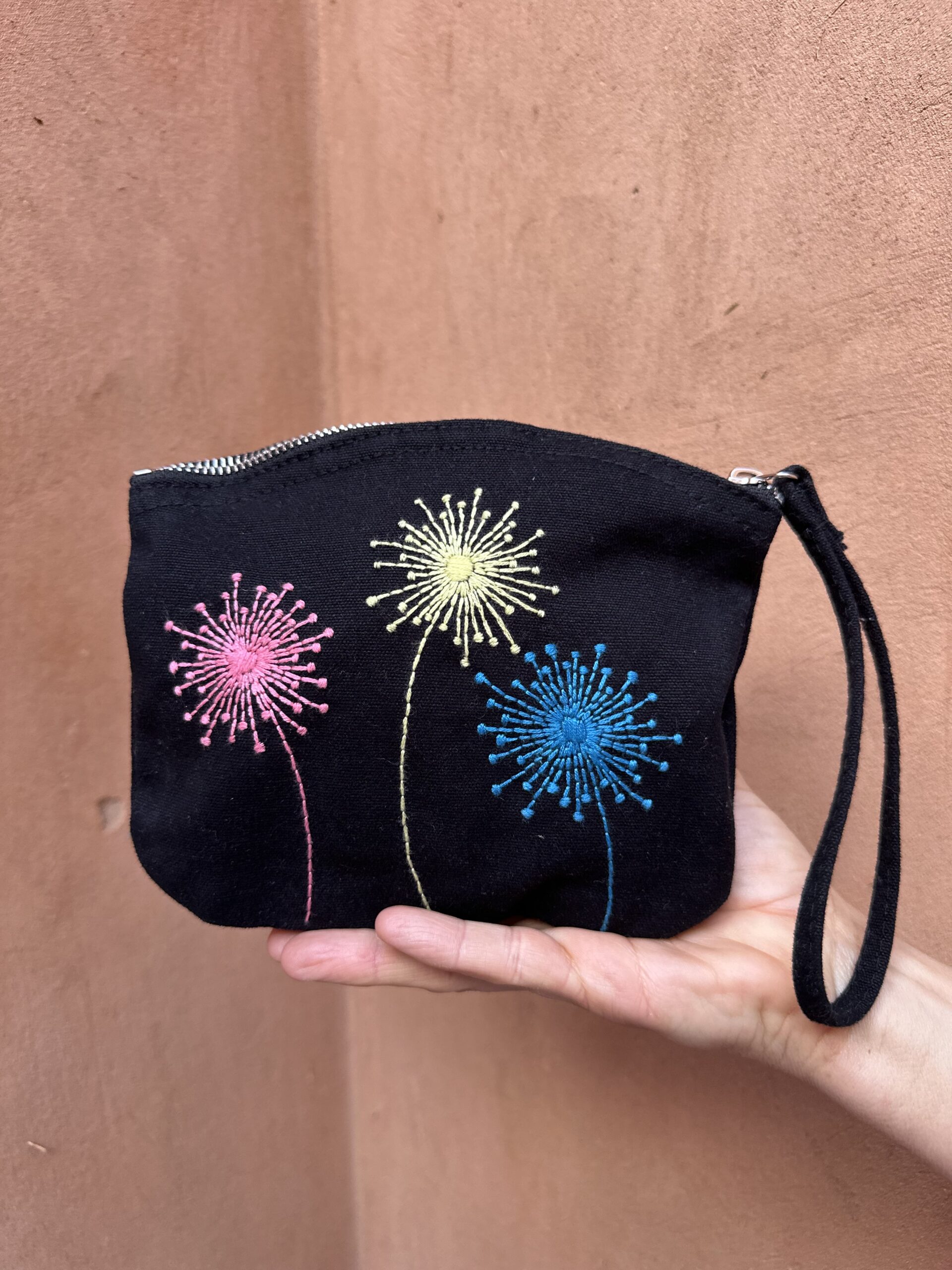 Pochette à anse noire avec décorations colorées.