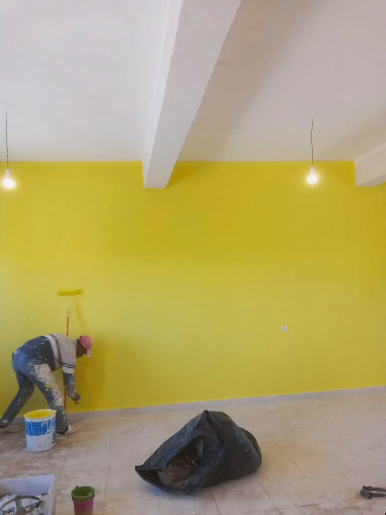 vue intérieure de la salle de classe entrain d'être peinte en jaune