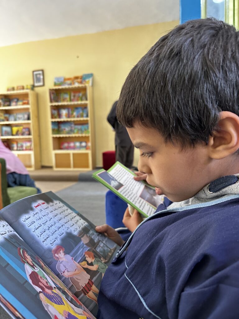enfant lit un livre de la nouvelle bibliothèque en arabe