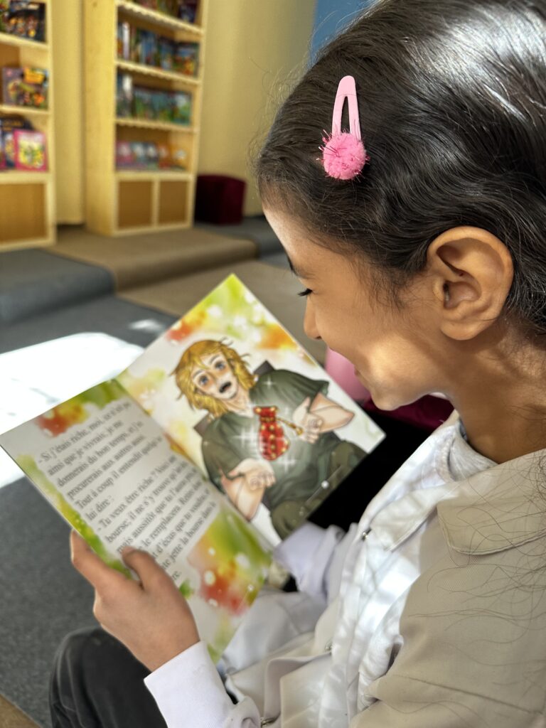 une enfant lit un livre dans la bibliothèque