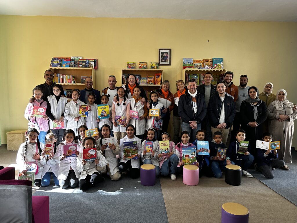 les enfants, équipe pédagogique et association enfants du désert posent dans la nouvelle bibliothèque