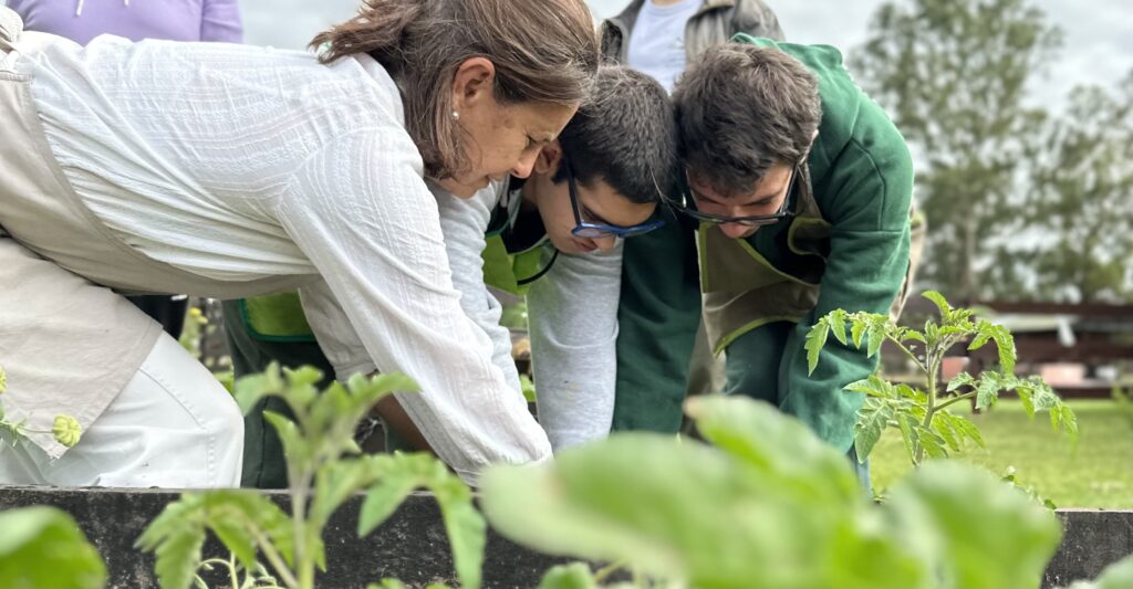 adolescents en atelier jardinage plantent des tomates avec une animatrice. Atelier mis en place grâce au soutien de la fondation carrefour