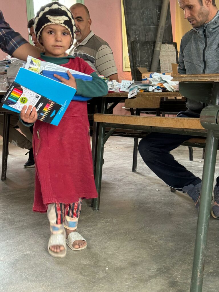 enfant reçoit matériel scolaire