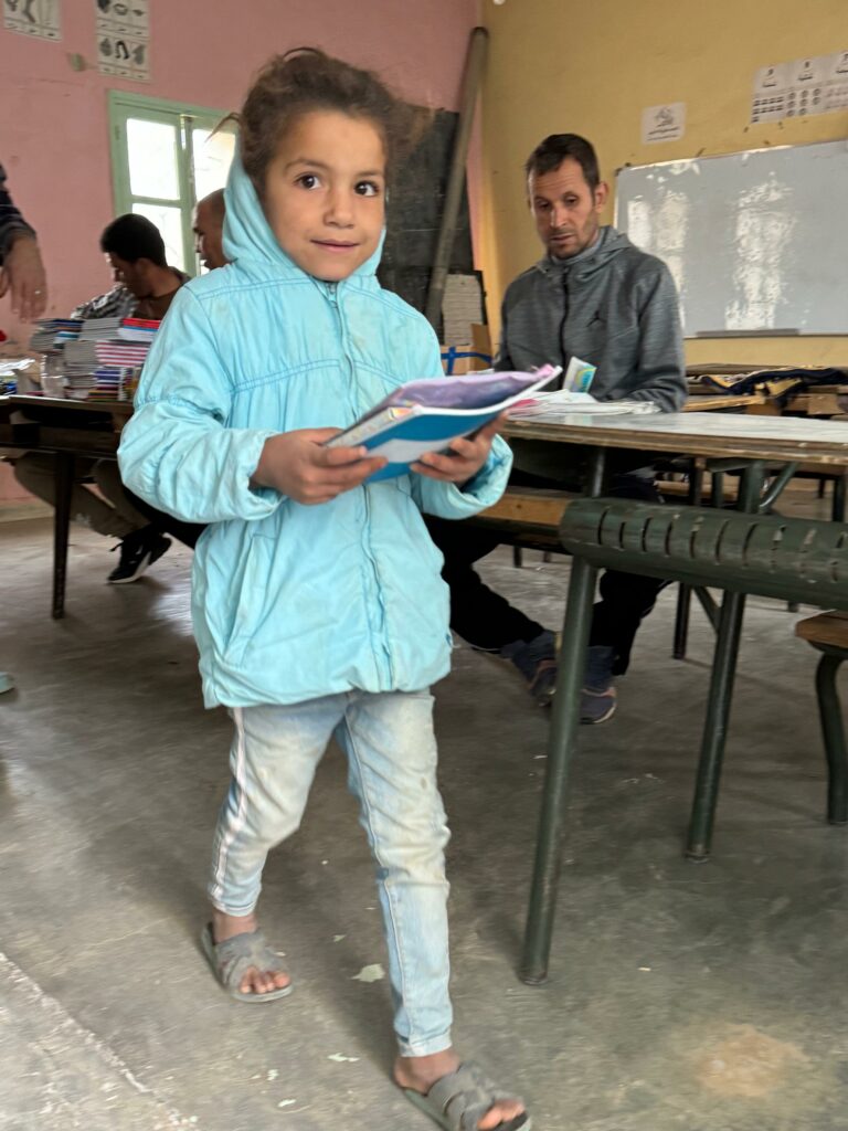 enfant reçoit matériel scolaire