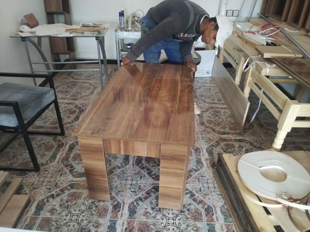 menuisier fabrique meubles (table) pour les bibliothèques 